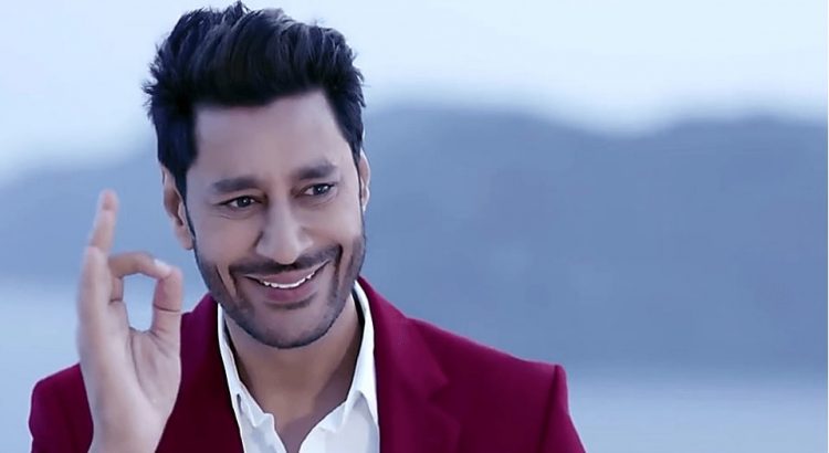 Punjabi singer Harbhajan Mann smiling and gesturing positively in an outdoor setting.