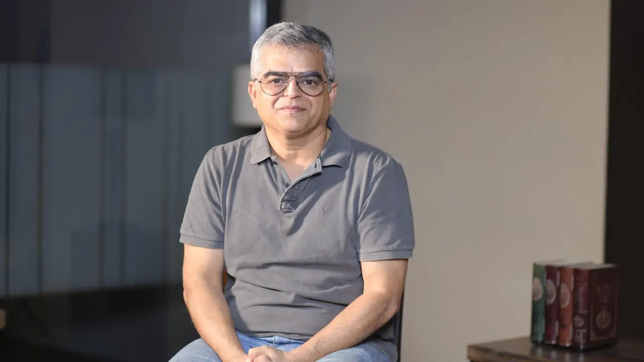Atul khatri sitting on a table and posing for image
